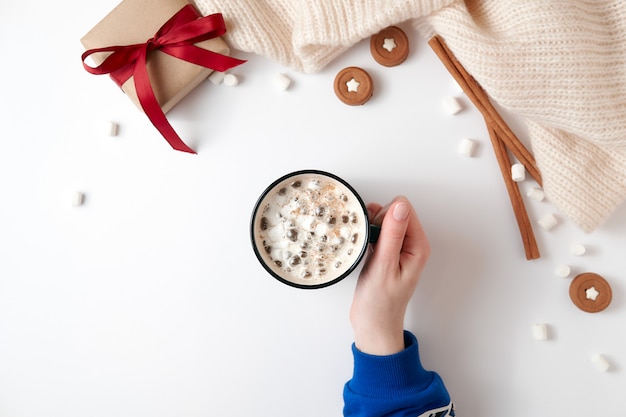 Vrouwelijke hand met een kop warme chocolademelk met marshmallow