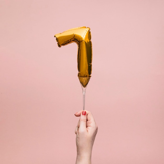 Vrouwelijke hand met een nummer verjaardag verjaardag viering gouden ballon