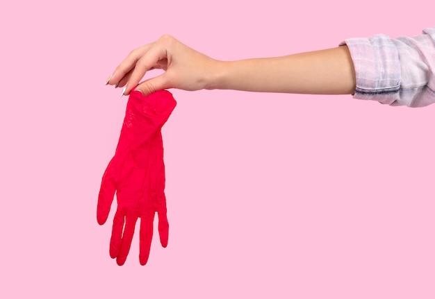 Vrouwelijke hand met een roze rubberen handschoen