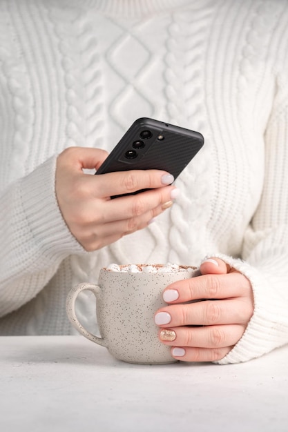 Vrouwelijke hand met kopje warme chocolademelk