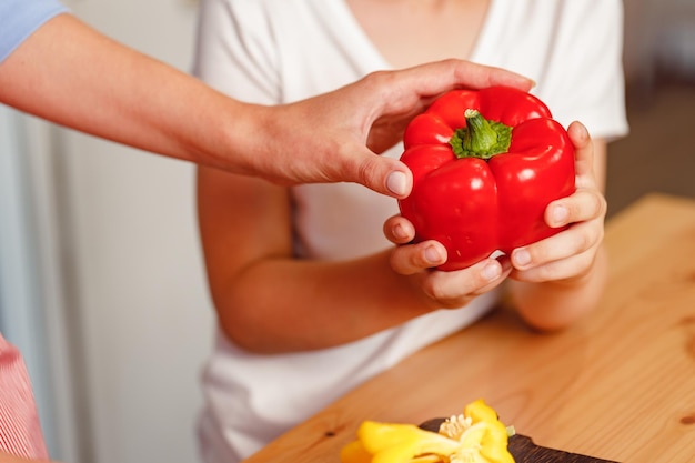 Vrouwelijke hand met paprika boven tafel