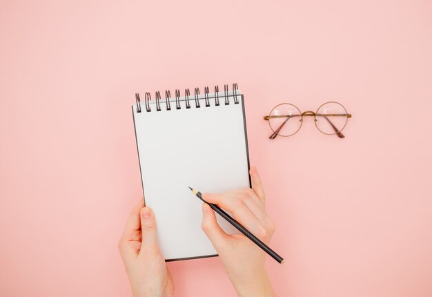 Vrouwelijke hand met potlood en schetsboek.