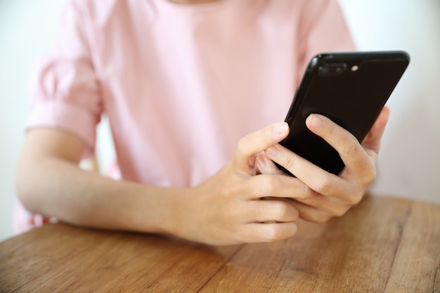 Vrouwelijke hand met smartphone handelsvoorraad online in koffiewinkel, Bedrijfsconcept