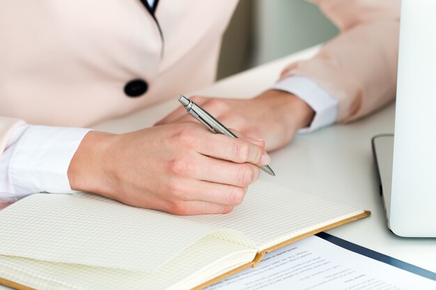 Vrouwelijke hand met zilveren pen close-up