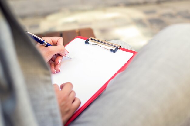 Vrouwelijke hand schrijven op een lege planner