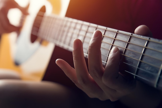 Vrouwelijke hand spelen op akoestische gitaar close-up