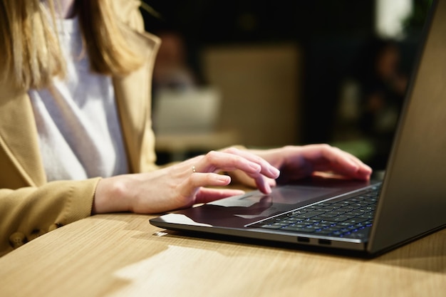 Vrouwelijke hand typen op laptop toetsenbord in café