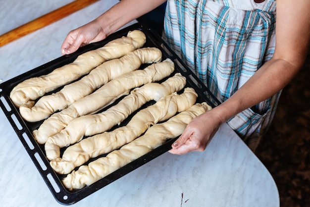 Vrouwelijke handen die deeg maken om zelfgemaakt voedsel te bereiden concept van het kookproces van het bakken van zelfgemaakte gerolde borek-taarten