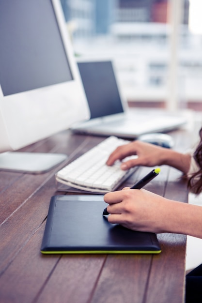 Vrouwelijke handen die digitaal raad en computertoetsenbord in bureau gebruiken