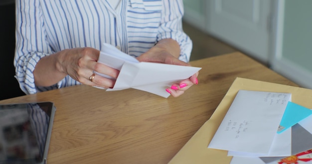 Foto vrouwelijke handen die een brief in een envelop terugbrengen vrouw stuurt een retourformulier per brief