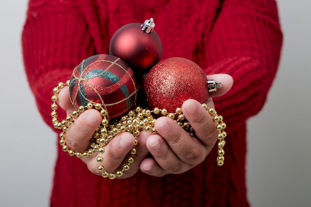 Vrouwelijke handen die een Kerstmisbal houden