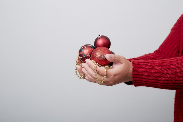 Vrouwelijke handen die een Kerstmisbal houden