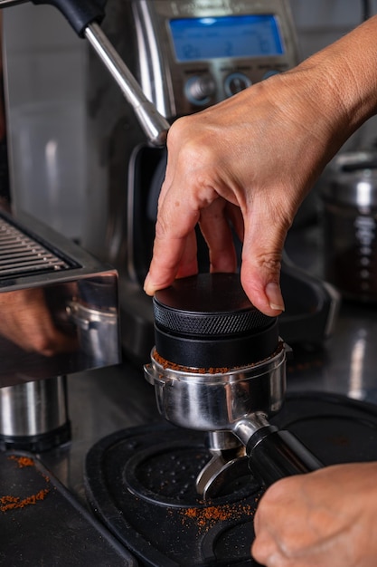 Foto vrouwelijke handen die geroosterde en gemalen koffie drukken voor gebruik in een koffiemaker