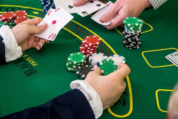 Vrouwelijke handen die reiken naar pokerfiches, speelkaart in casino