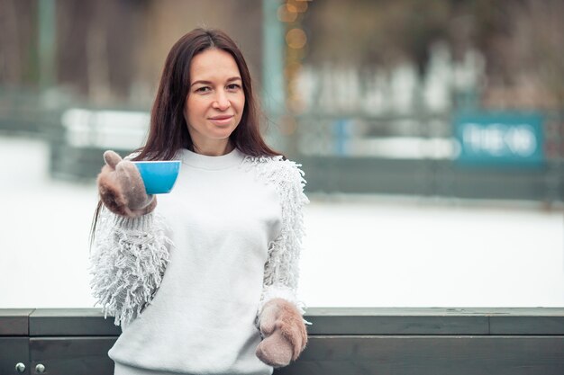 Vrouwelijke handen holdink witte kop koffie met witte en roze marshmallows