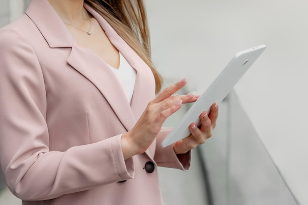 Vrouwelijke handen houden een tablet vast en bekijken analyses van bankstatistieken