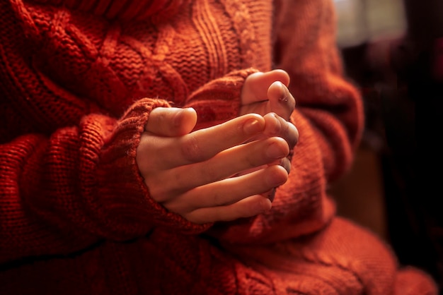 Vrouwelijke handen in een warm thema van de sweaterhitte