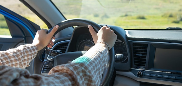 Vrouwelijke handen in het stuur van de auto