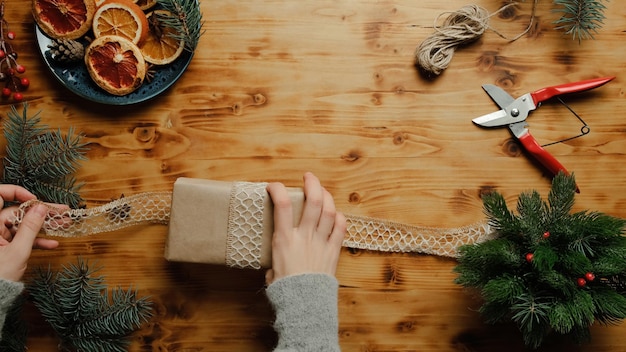 Vrouwelijke handen kerstcadeau inpakken Voorbereiding voor Kerstmis