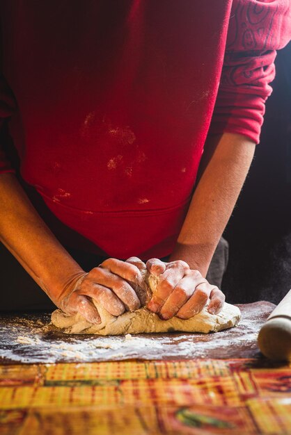 Vrouwelijke handen kneden het deeg