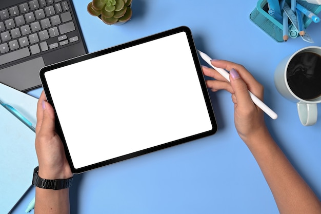 Vrouwelijke handen met digitale tablet met leeg scherm en styluspen.