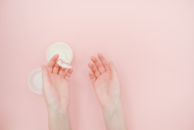 Vrouwelijke handen met een doos handcrème. Hand huidverzorging concept.