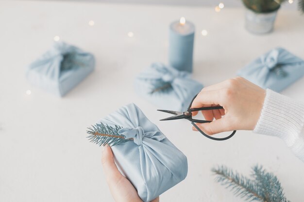 vrouwelijke handen met een geschenkdoos met blauwe stof