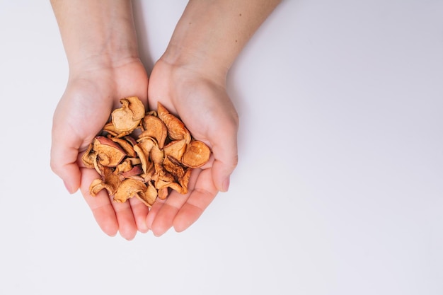 Vrouwelijke handen met gesneden gedroogde tuinappels Gedroogd fruit Gezonde natuurlijke voeding Witte achtergrond Close-up