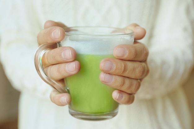 Vrouwelijke handen met kopje groene matcha thee close-up