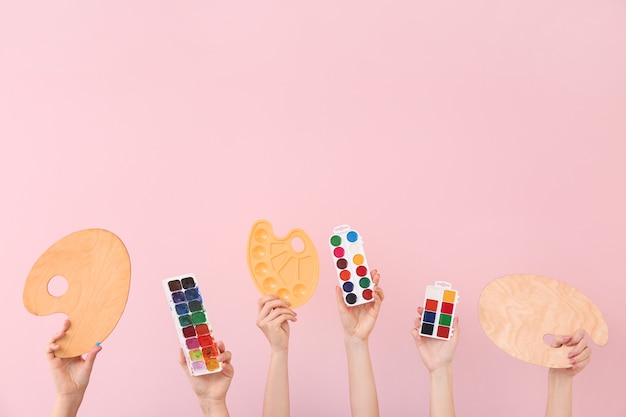 Vrouwelijke handen met schilderspullen op roze