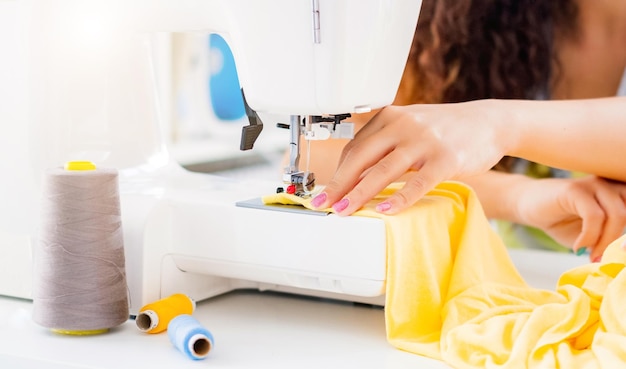 Vrouwelijke handen op naaimachine