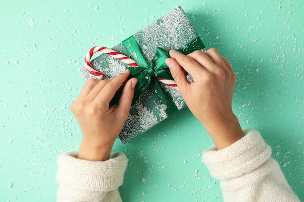 Vrouwelijke handen openen de geschenkdoos op munttafel