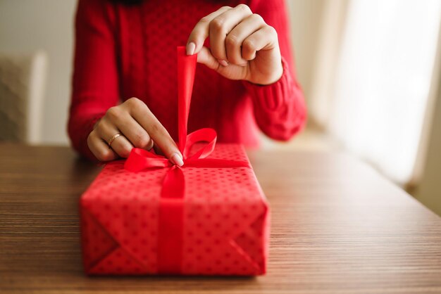 Vrouwelijke handen openen rode geschenkdoos Een geschenk uitpakken Valentijnsdag viering concept