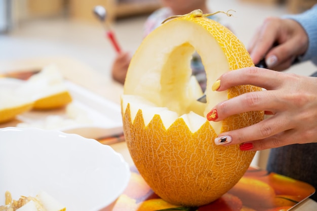 Vrouwelijke handen snijden pompoen tot halloween op de kleuterschool