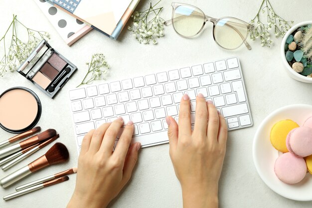 Vrouwelijke handen typen op toetsenbord op de achtergrond met accessoires voor vrouwen