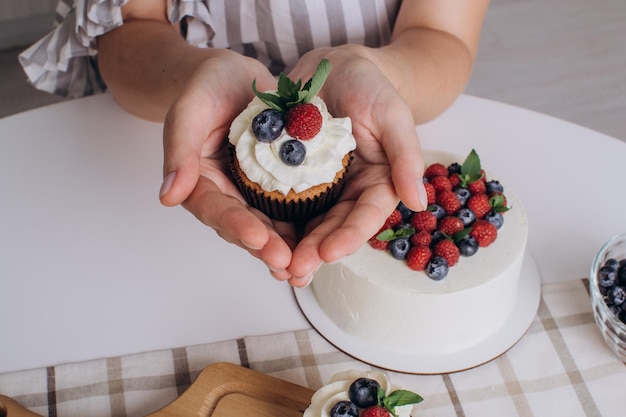 Vrouwelijke handen van een banketbakker houden een cupcake