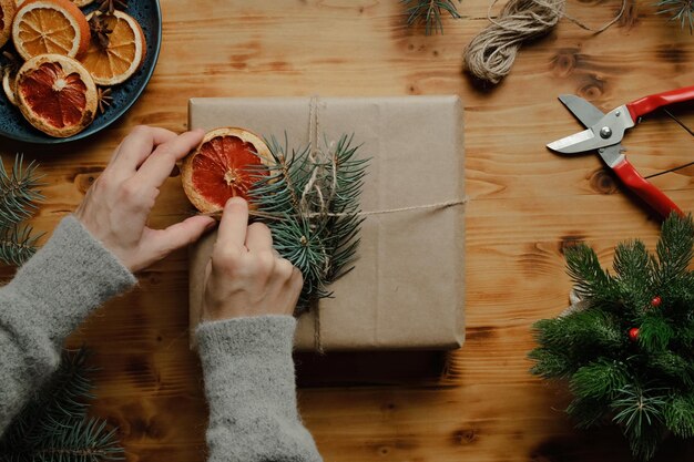 Vrouwelijke handen versieren kerstcadeau