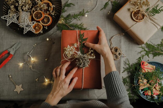 Vrouwelijke handen versieren kerstcadeau