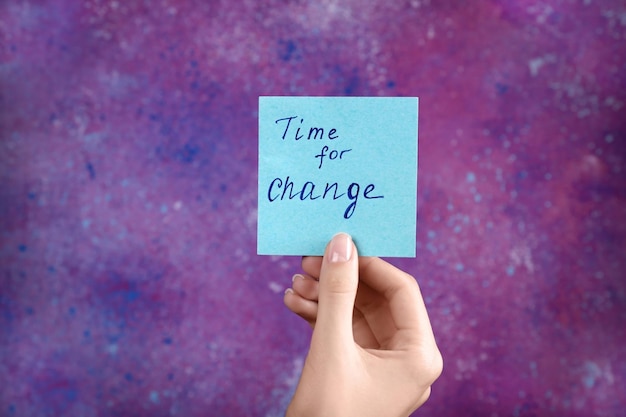 Foto vrouwelijke handkaart met de tekst time for change op kleurachtige achtergrond