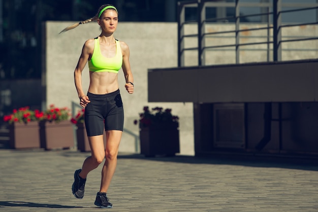 Vrouwelijke hardloper, atleet die buiten traint op een zonnige zomerdag.