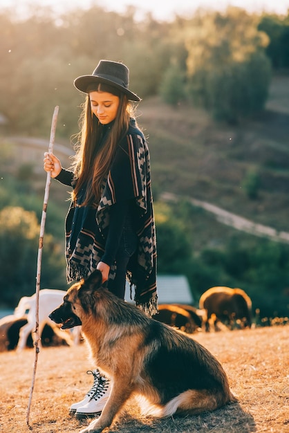 Foto vrouwelijke herder met een hond graast een kudde op het gazon
