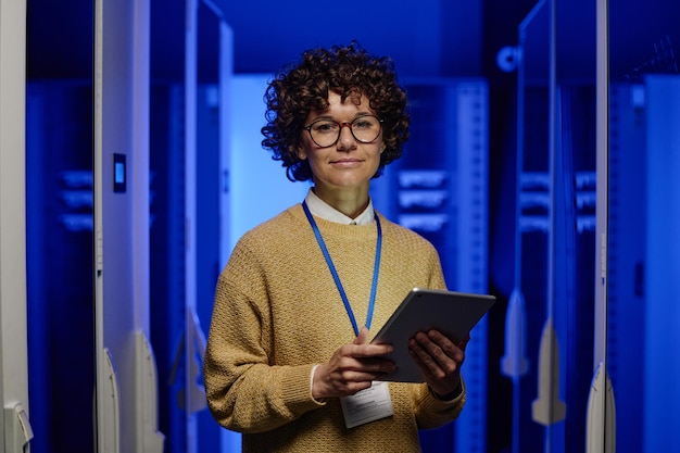 Foto vrouwelijke ingenieur die zich bij serverruimte bevindt