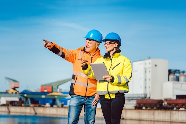 Vrouwelijke ingenieur met collega met digitale tablet tegen de lucht