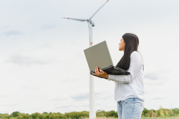 Vrouwelijke ingenieur op het windturbinepark die op laptop werkt