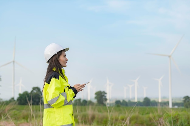 Vrouwelijke ingenieur werkt en houdt het rapport vast bij het Power Generator Station van het windturbinepark op mensen uit bergThailand