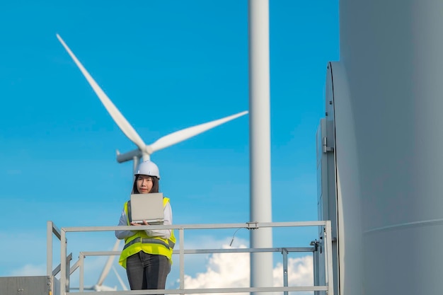 Vrouwelijke ingenieur werkt en houdt het rapport vast bij het Power Generator Station van het windturbinepark op mensen uit bergThailand