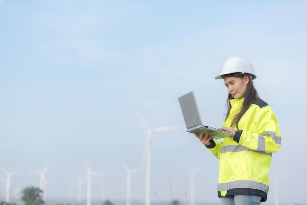 Vrouwelijke ingenieur werkt en houdt het rapport vast bij het Power Generator Station van het windturbinepark op mensen uit bergThailand