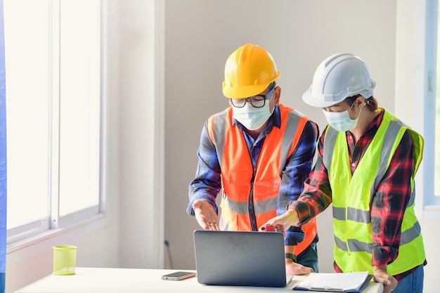 Foto vrouwelijke inspecteurs en architecten bespreken met hoofdingenieur over bouwproject. multi-etnische groep ingenieurs die in de avond op de bouwplaats bijeenkomen