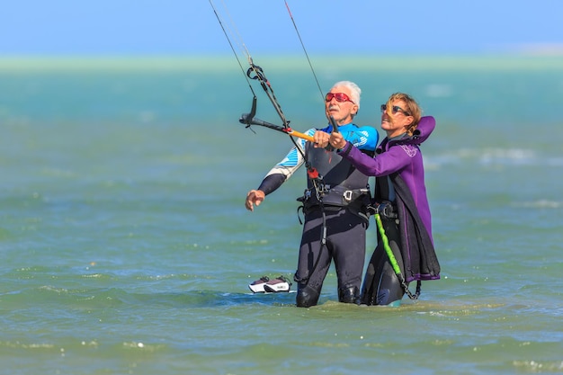 Vrouwelijke instructeur leert de oude man die zich bezighoudt met kitesurfen Hamata Egypt