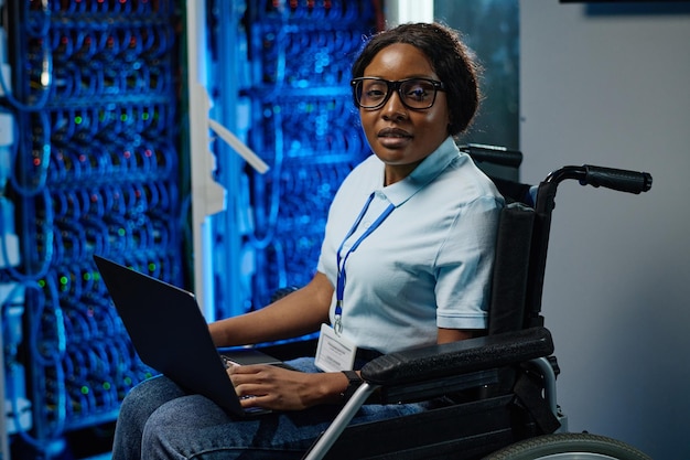 Vrouwelijke IT-ingenieur met een handicap die op laptop werkt